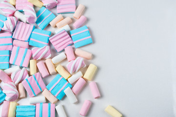 Abstract background with lots of colorful pink, blue and yellow marshmallows. Flat lay overhead