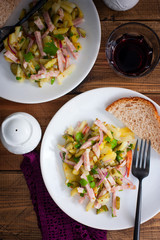 traditional german potato salad with sausage and pickled cucumbers, selective focus