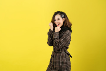 Asian woman, she is happy. She is with a yellow background.
