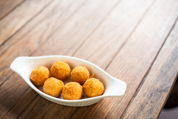 Cheese ball with plate shaped boat placed on wooden table
