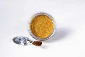 Gold eye shadows and eye brush  isolated on white background. Concept of makeup and beauty.