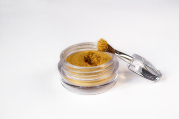 Gold eye shadows and eye brush  isolated on white background. Concept of makeup and beauty.