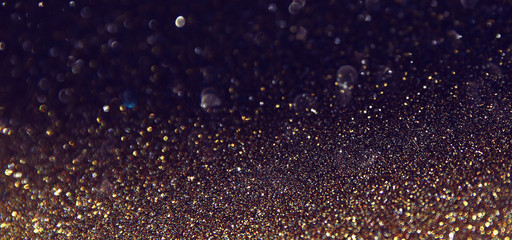 background of abstract glitter lights. gold and black. de focused