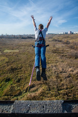 man bungee jumping on green meadow background