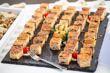 Assortment of various snacks and canapes on a plate during a coffee break at a business seminar