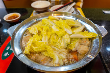 The boiling food in the pot consists of vegetables and meats that are hot and pleasant to the body