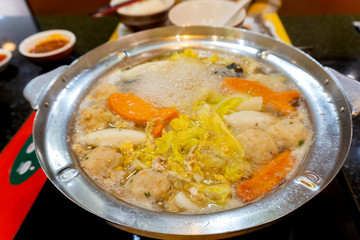 The boiling food in the pot consists of vegetables and meats that are hot and pleasant to the body