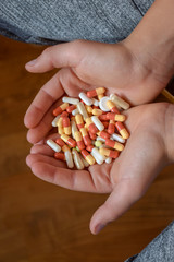 picture with human hands holding medicine pills or capsules