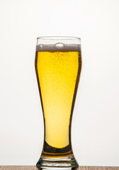  light filtered beer with a transparent glass on a white background with bubbles