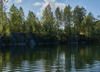 Fototapeta na wymiar Water landscape of a mountain park.The picturesque landscape of the mountain natural park Ruskeala. Visible are rocks, a lake, coniferous forest, mountains, wildlife. Russia, Karelia.