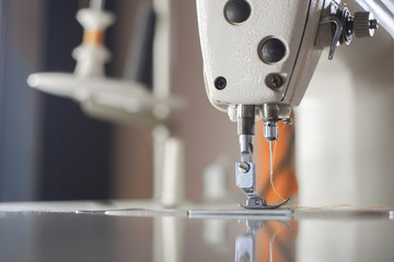 Close-up needle of white industrial sewing machine use sew cloth.
