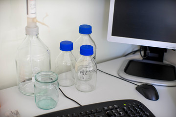 Bottles of chemicals and a computer on the table