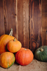 autumn set of pumpkins and dried leaves on a wooden background