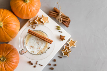 Pumpkin spice latte in a glass on a gray background. Top view, copy space. Selective focus.