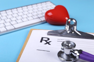 Medical stethoscope and red heart lying on cardiogram chart closeup. Medical help, prophylaxis,...