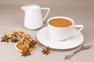 Masala tea is a traditional Indian drink in a Cup with spices on a light background