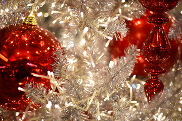 Close up of red ornaments on a white Christmas tree