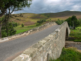 landscape with a rocky country road over the old bridge