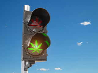 Cannabis and marijuana legalization concept.  Symbol of cannabis leaf on green traffic light.
