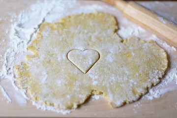the dough for the shortbread in a heart shape on cutting Board