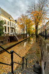 Man sitting on stairs leading to canal in historic city center of Utrecht, the Netherlands              