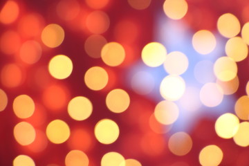 Many soft orange, red and yellow blurry bokeh light on dark red background in Christmas and New...