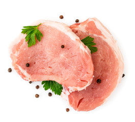 Two pieces of raw meat pork with parsley leaves and peppers on a white background. The view of top.