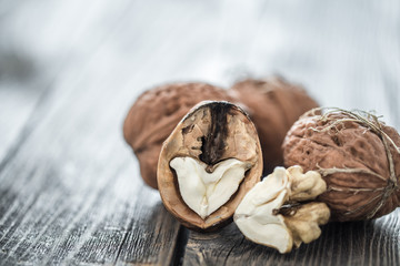 Walnut in open form on a wooden background, close-up .
