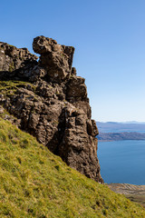 Rugged mountains on the Isle of Skye coast, with a blue sky overhead
