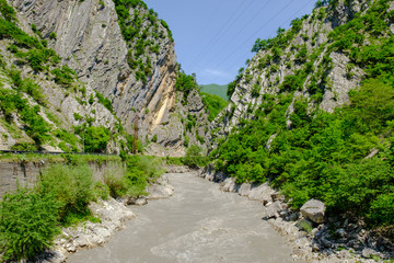 Mountains river flowing between tree forest and rocks. Scenic view. Georgia country, Racha region.