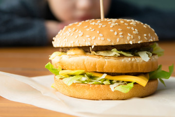 double big burger on blurred baby face background