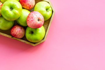Healthy diet concept. Fresh apples in tray on pink background top view copy space