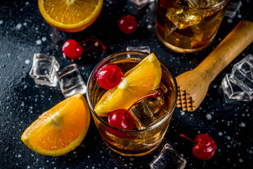 Whiskey with orange and cocktail cherries