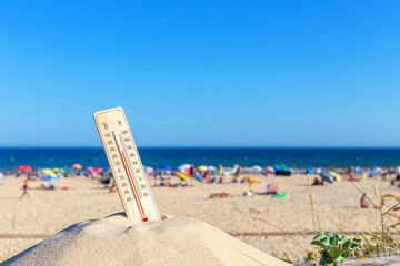 Thermometer for the temperature on the beach, in the summer in the heat. Global warming.