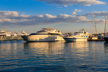 Fototapeta na wymiar White yachts in the sea harbor of Hurghada, Egypt. Port with tourist boats on the Red Sea
