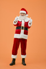 Full length portrait of happy Santa Claus showing thumbs up
