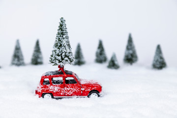 Rotes Auto mit Weihnachtsbaum in einer Schneelandschaft (Modellbau)