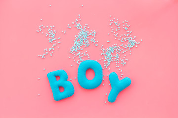 Boy word as decoration for baby shower on pink background top view