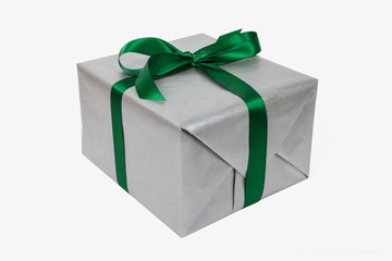 Silbernes Weihnachtsgeschenk mit grüner Schleife als Freisteller