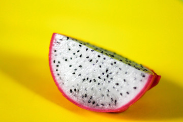 Dragon fruit slice against a bright yellow background showing summer freshness and pop culture