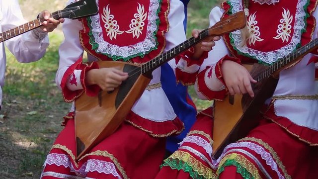 Children's Ensemble in Embroided Costumes Playing Music on Balalaika, Traditional Russian Musical Instrument