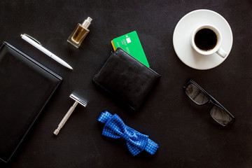 Set of men's accessories. Bow tie, razor, wallet with credit cards, notebook, coffee on black background top view flat lay pattern
