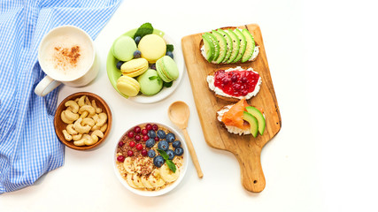 breakfast top view isolate white background. oatmeal with berries, toasts on a wooden tray, nuts, coffee