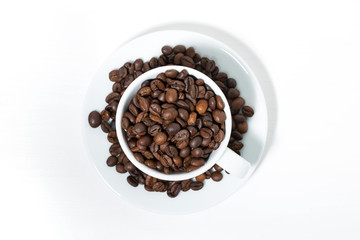 cup with coffee beans on white background, top view