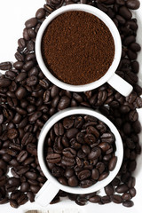 cups with ground coffee and coffee beans, top view closeup