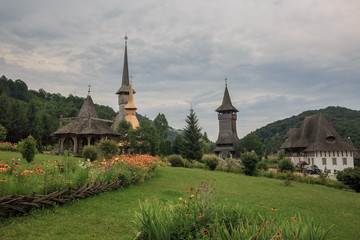 Fototapeta na wymiar Panoramic view of traditional ancient Maramures wooden orthodox church in Transylvania with highest wooden belltower in Europe, Romania. UNESCO world heritage site.