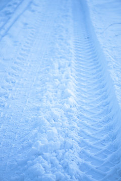 Tread texture of car wheels on snow. Winter road in January, December. Rural area and background of tractor tracks in the snow