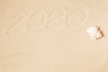Happy New Year 2020, lettering on golden sand beach. Flat lay, top view, copy space