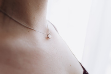 Girl with gold diamond pendant. Gold pendant with stone.