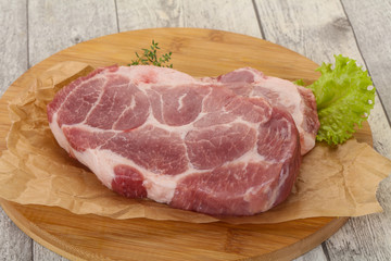 Raw pork steak over wooden board